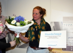 Anneke Vervoort neemt namens Van Hoogmoed Architecten de prijs en bloemen in ontvangst 